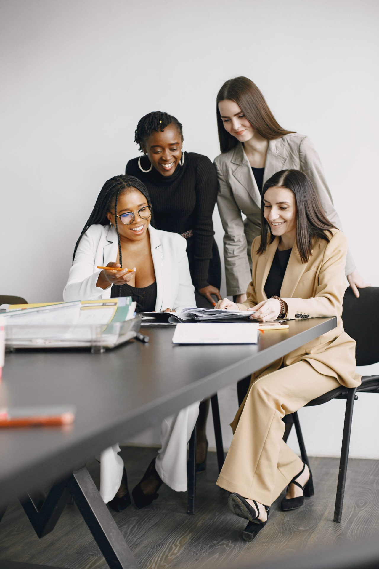 Four professional women collaborating around a meeting table
